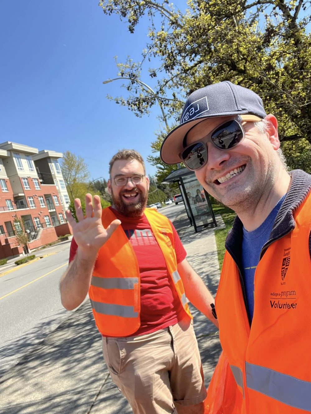 Two volunteers waving at a clean-up