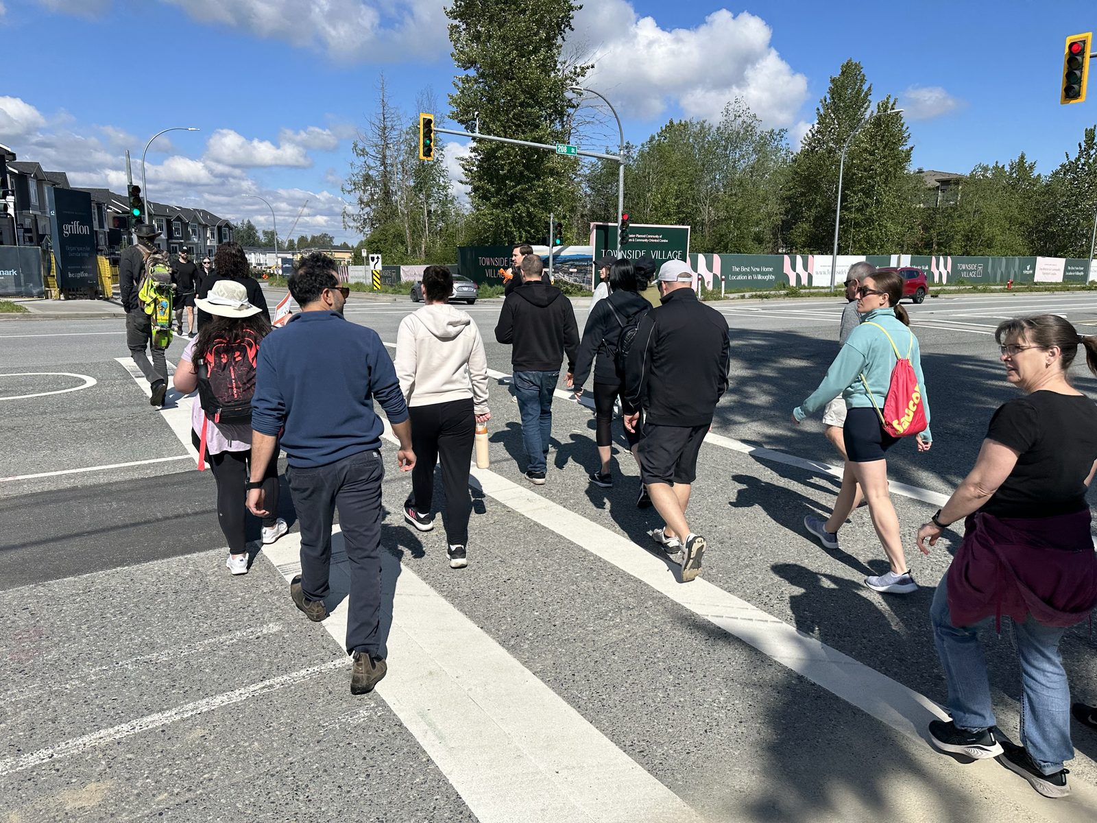 A walking group crossing 208 Street